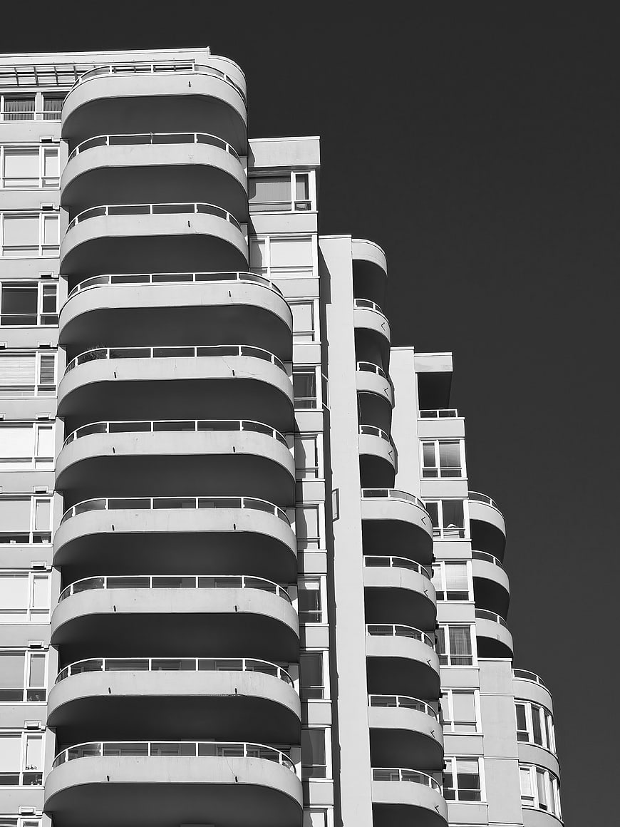 Black and white modern apartment building with curved balconies