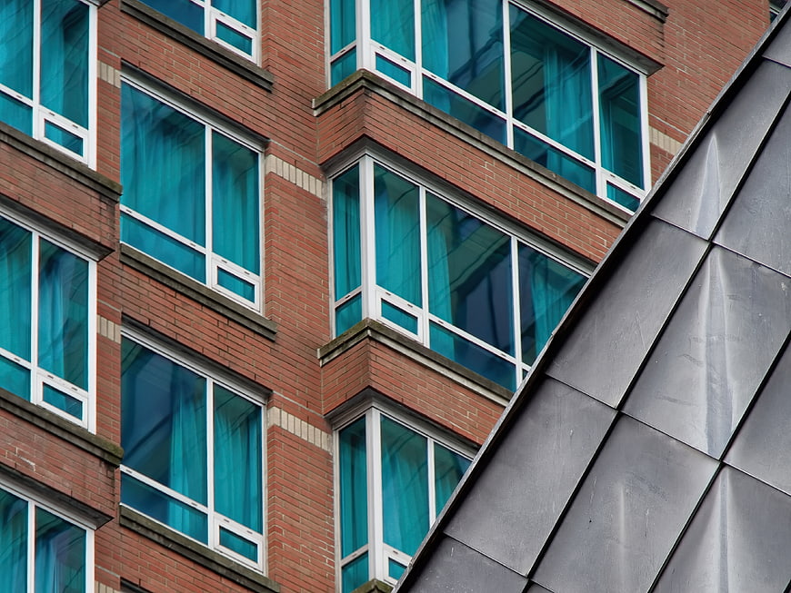 Modern Brick Building Facade with Blue Windows and Metal Roof