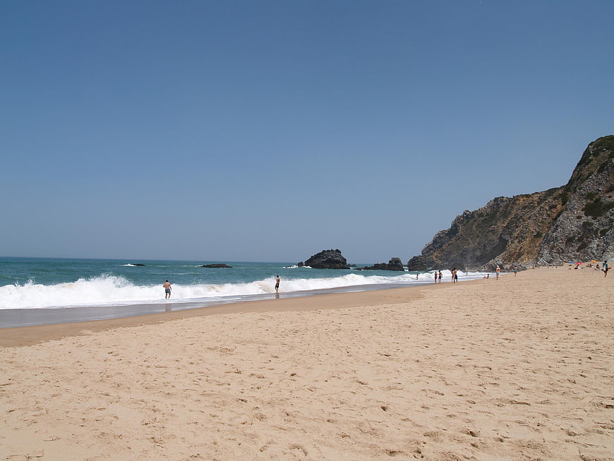 Sandy Beach with Ocean Waves and Rocky Cliffs