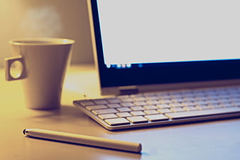 Laptop, Coffee Cup, and Pen on Desk Workspace