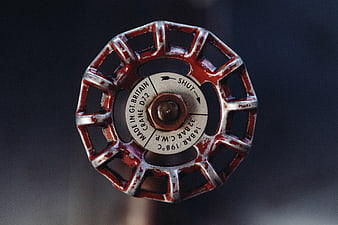 Close-up of vintage red industrial valve wheel with text