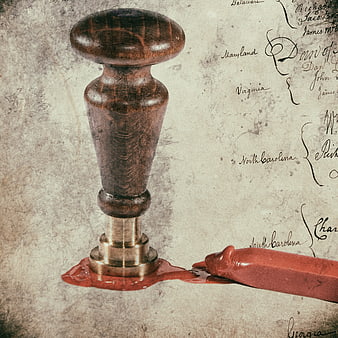 Vintage wooden wax seal stamp with red wax on aged parchment