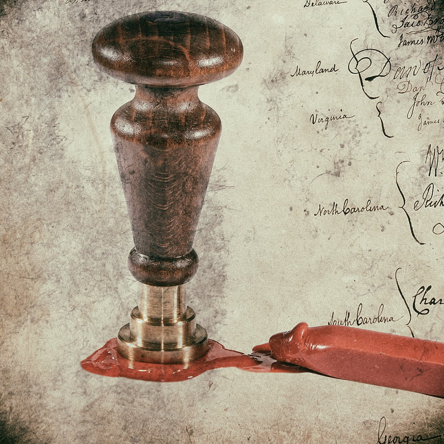 Vintage wooden wax seal stamp with red wax on aged parchment