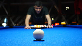 Man Playing Billiards with Blue Felt Table