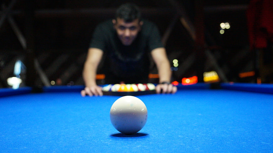 Man Playing Billiards with Blue Felt Table