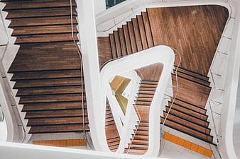 Modern spiral staircase with wooden steps and white curves