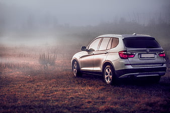 Silver BMW X3 SUV in foggy field