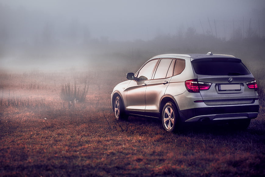 Silver BMW X3 SUV in foggy field