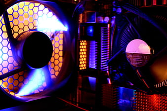 Close-up of RGB PC cooling fans with hexagonal mesh and neon lighting