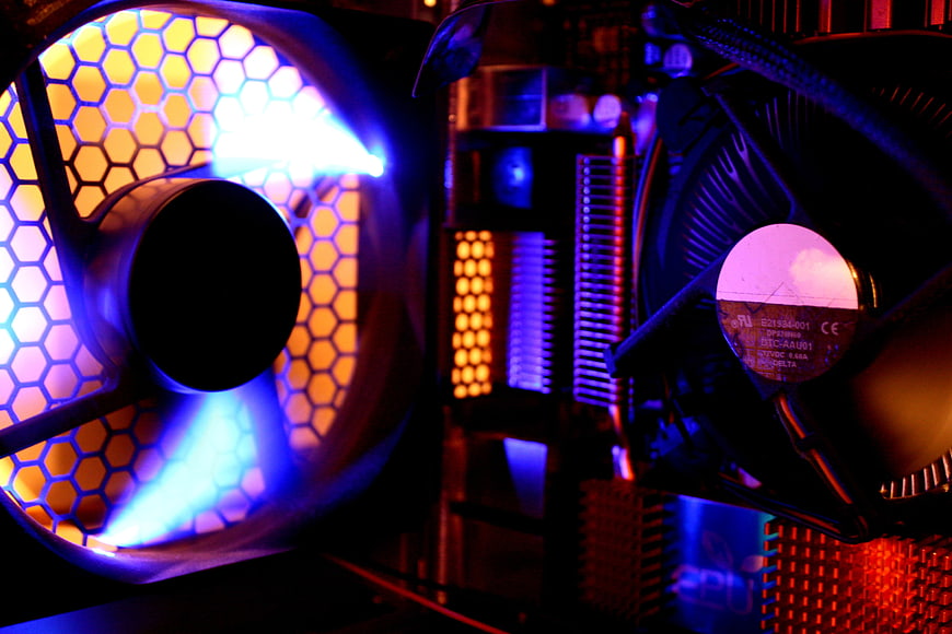Close-up of RGB PC cooling fans with hexagonal mesh and neon lighting