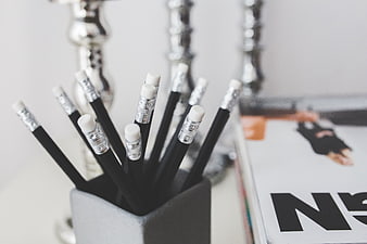 Black pencils in gray holder on desk