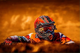 Motocross Rider in Orange Gear Leaning Through Dust Cloud