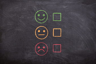 Customer satisfaction feedback scale with smiley faces and checkboxes on blackboard