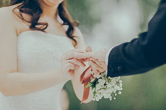 Bride Placing Wedding Ring on Groom's Finger