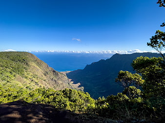 Scenic tropical mountain landscape with lush green valley and blue ocean view