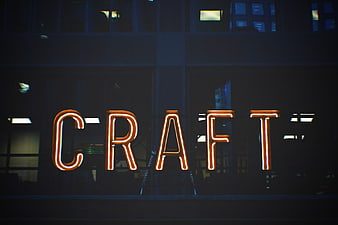 Glowing Orange Neon Craft Sign on Dark Building