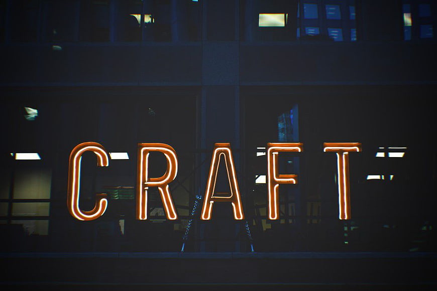 Glowing Orange Neon Craft Sign on Dark Building