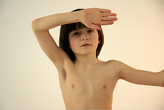 Young boy shielding eyes looking forward