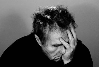 Black and white portrait of a distressed man holding his head