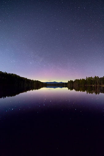 Starry Night Sky Reflection on Calm Lake with Forest Silhouette