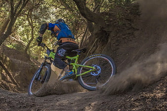 Mountain biker kicking up dust on forest trail