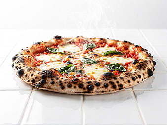 Hot Neapolitan Pizza with Fresh Basil on White Tiles