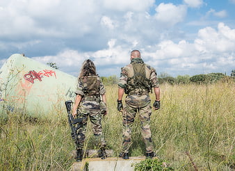 Soldiers in camouflage standing in a field with a crashed plane