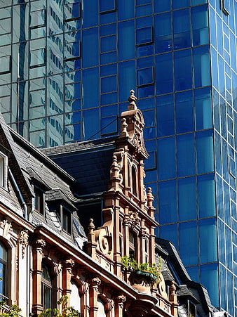 Old ornate building facade against modern blue glass skyscraper