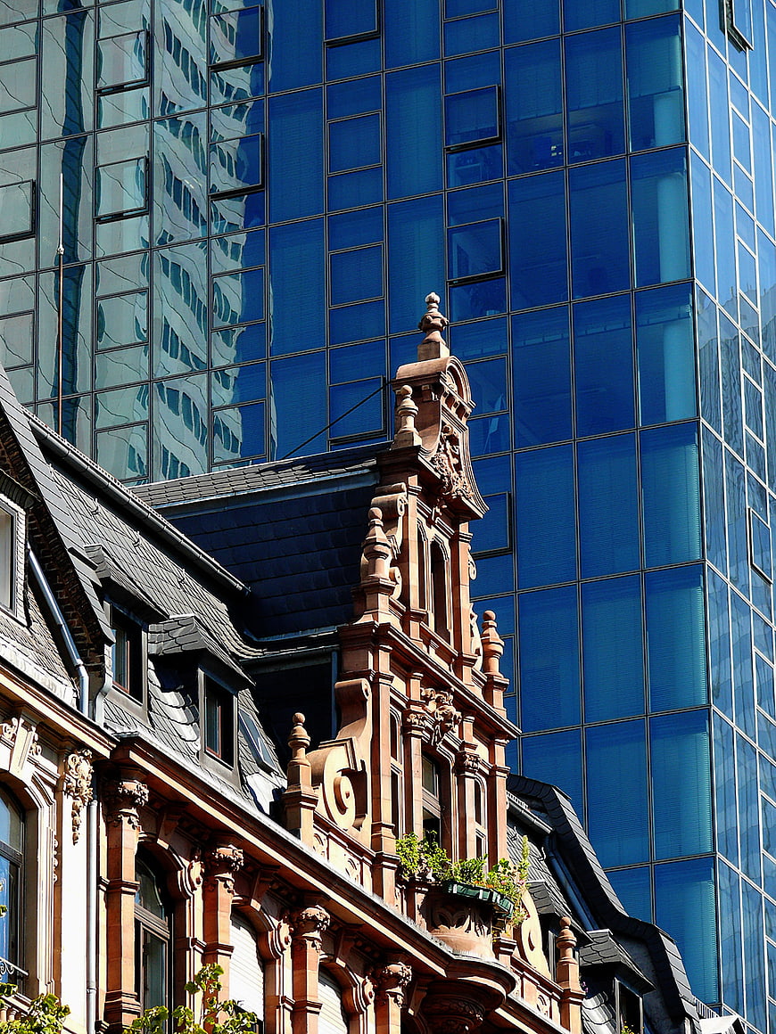 Old ornate building facade against modern blue glass skyscraper