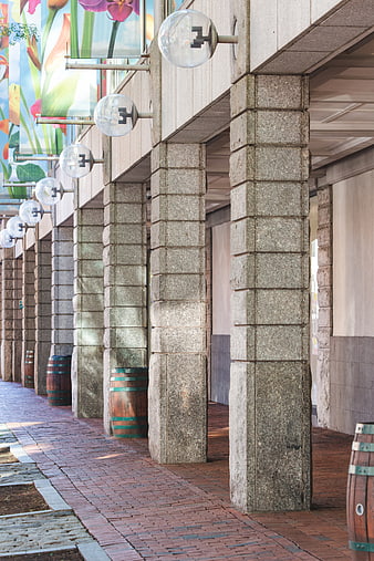 Perspective view of stone columns and brick walkway with glass lights