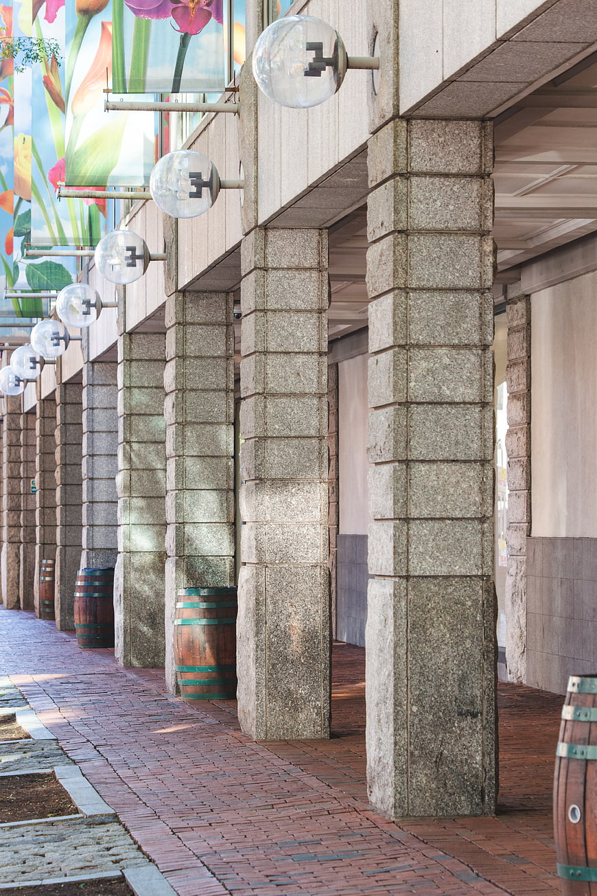 Perspective view of stone columns and brick walkway with glass lights