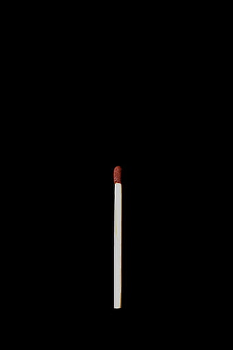 Single white matchstick on black background