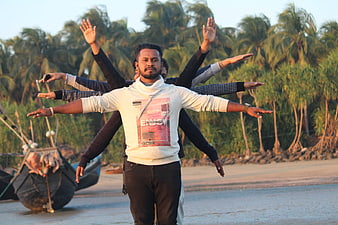 Group of friends posing with multiple arms on tropical beach