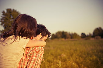 Couple Piggyback Ride in Golden Field at Sunset