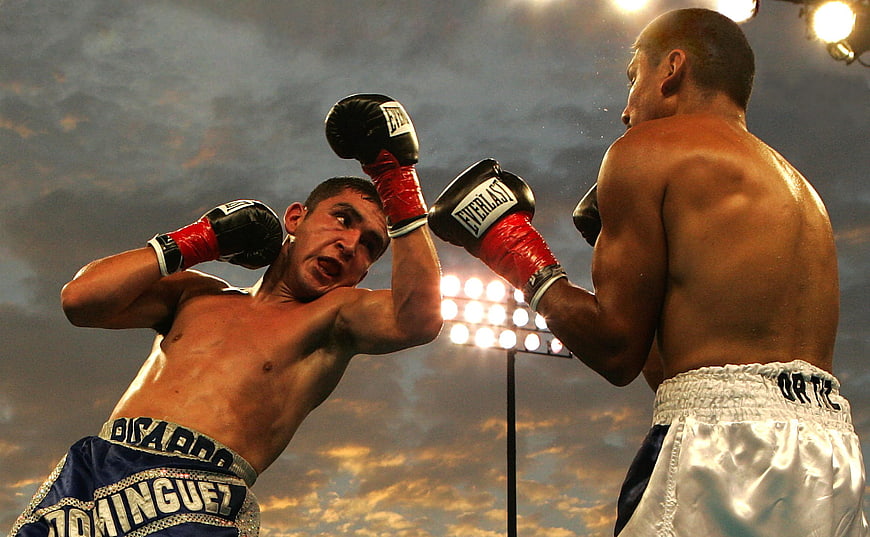 Two boxers fighting in a ring under stadium lights