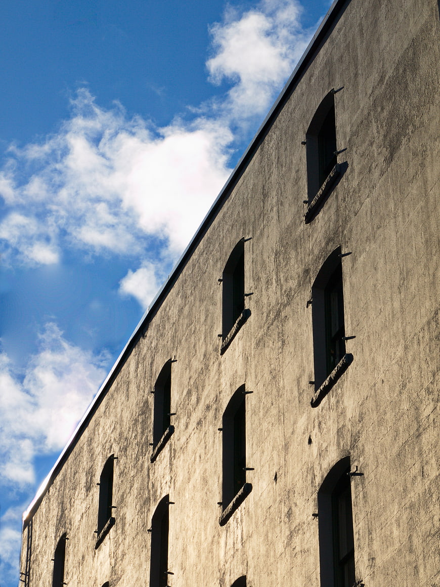 Low angle view of concrete building facade against blue sky