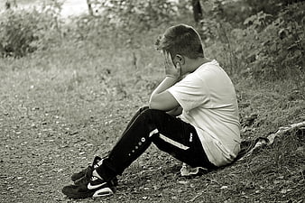 Sad Boy Sitting Alone in Forest Hiding Face