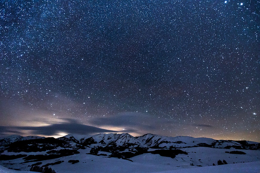 Starry Night Sky Over Snowy Mountain Landscape