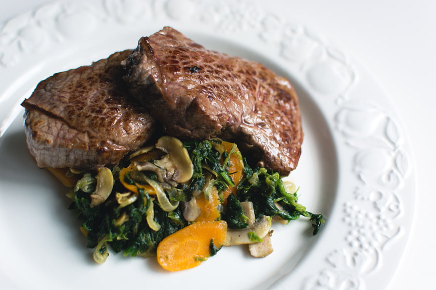 Grilled Beef Steak with Sautéed Vegetables on White Plate