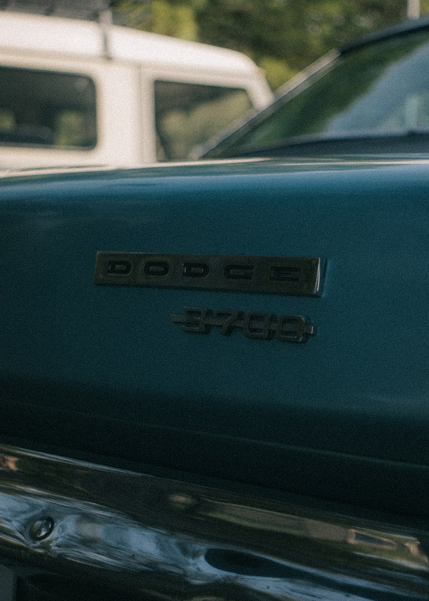 Close-up of vintage teal Dodge 3700 car emblem