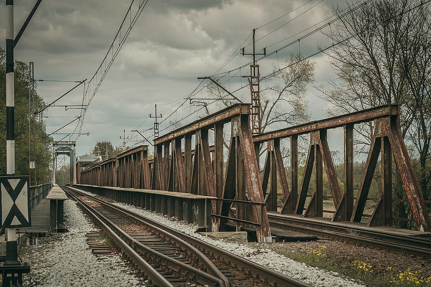 Rusty Railway Bridge Tracks Under Cloudy Sky