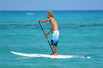 Man Stand Up Paddleboarding on Turquoise Ocean Water
