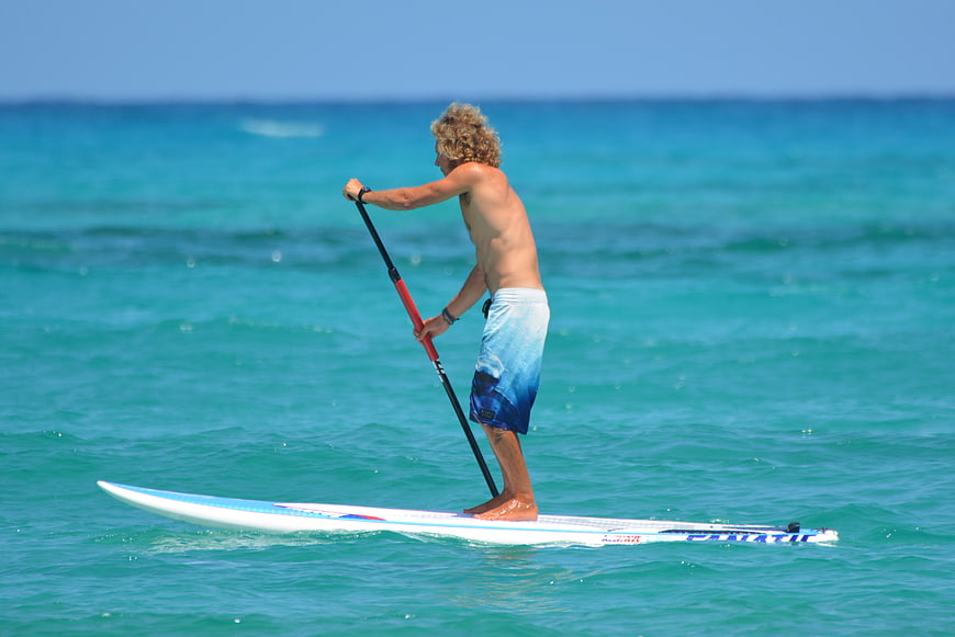 Man Stand Up Paddleboarding on Turquoise Ocean Water