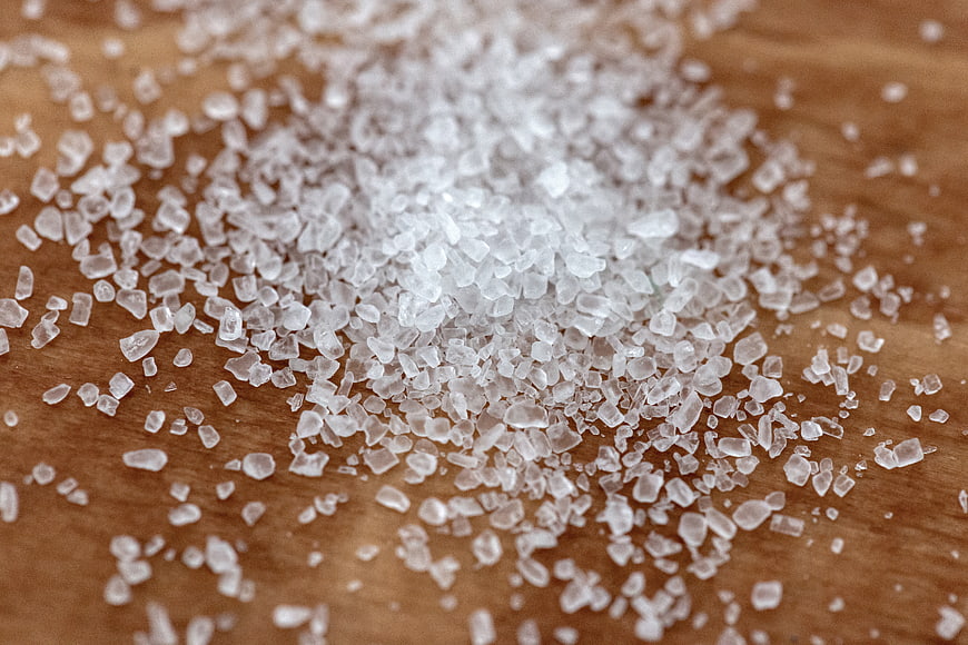 Close-up of coarse salt crystals on wooden surface