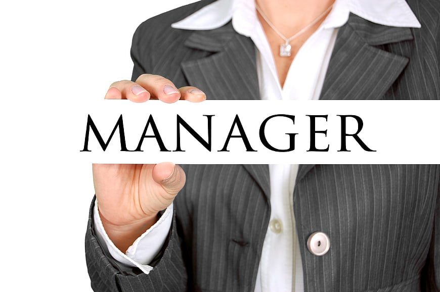 Businesswoman holding manager sign in pinstripe suit