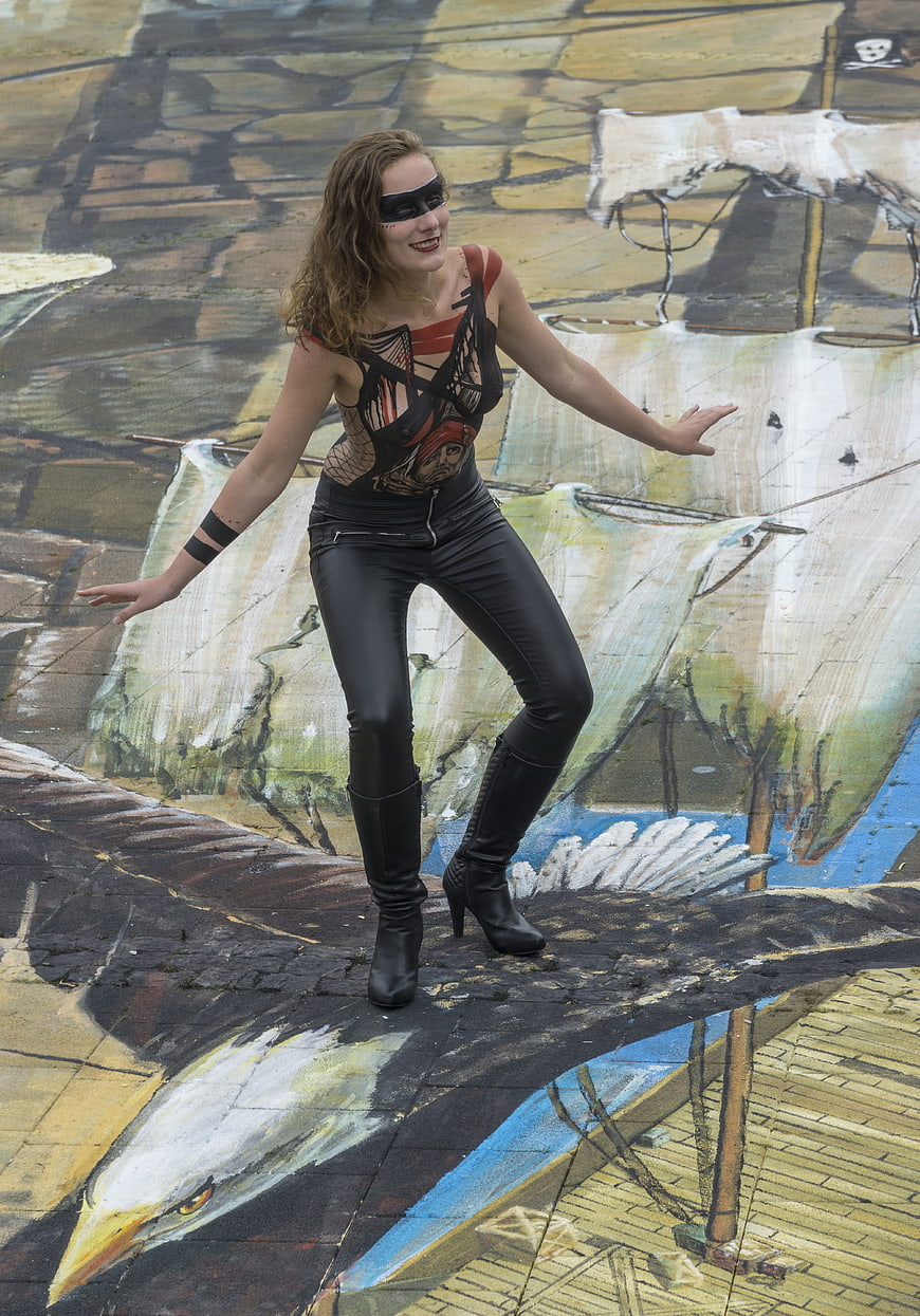 Woman in costume posing on 3D street art eagle mural