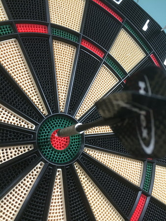 Close-up of a dart hitting the bullseye on a dartboard