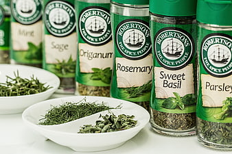 Assorted Dried Herbs in Glass Jars and White Bowls