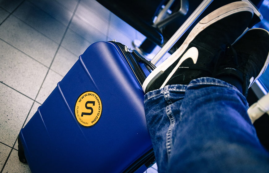 Blue suitcase and sneakers at airport terminal