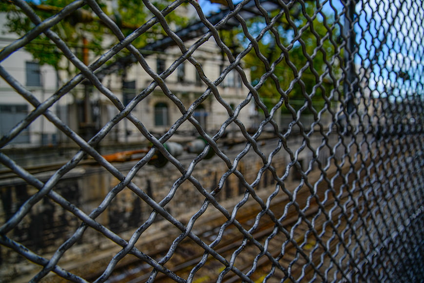 Chain link fence overlooking urban train tracks